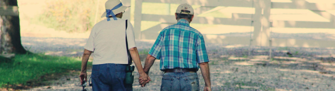 Older Couple Walking Down Path Holding Hands